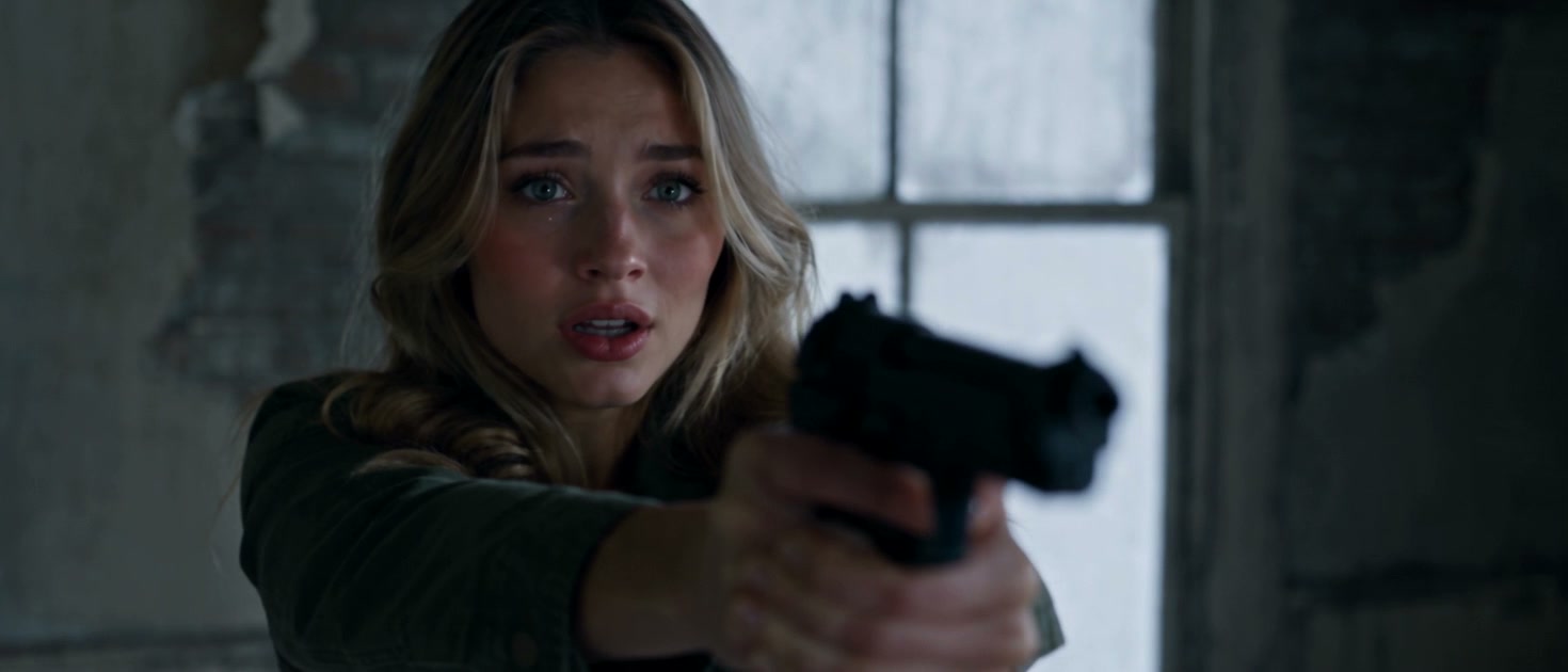 The standoff in a zombie apocalypse love story: a woman with tears in her eyes aims a pistol in a ruined cabin