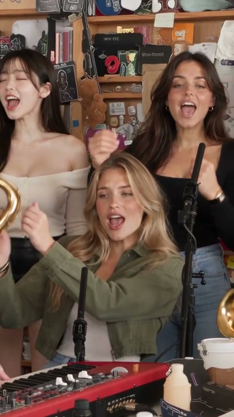 The band shot at 2.5 seconds of a Tiny Desk AI video: the keyboard player at the red keyboard with two backup singers behind